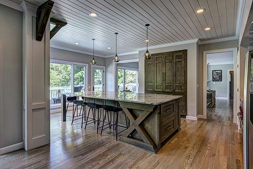 Country kitchen with rustic wood cabinetry and large windows