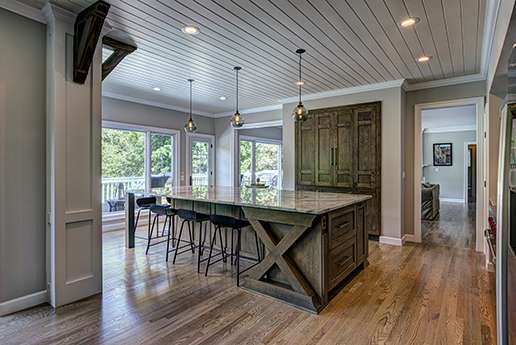 Country kitchen with rustic wood cabinetry and large windows