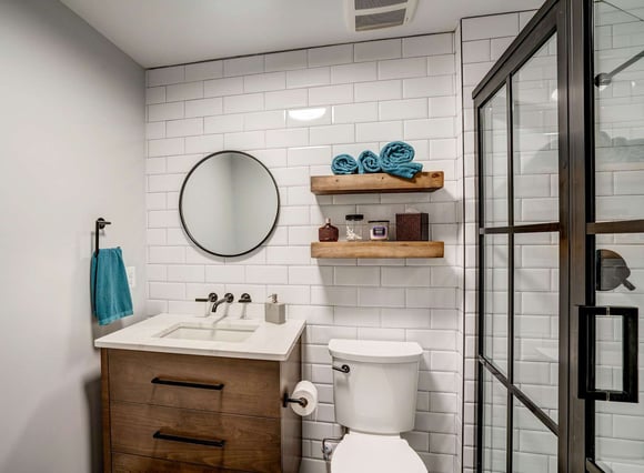 Small full bathroom with floating shelves and white tile backsplash