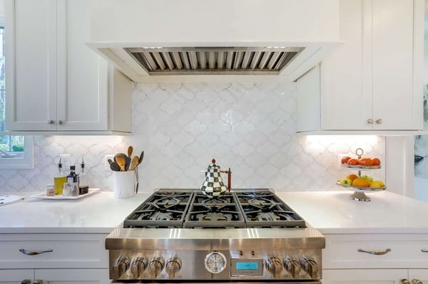 Country style kitchen with cream mermaid backsplash behind stove top
