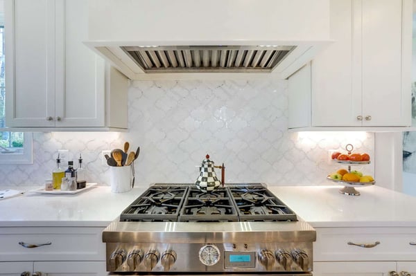 Country style kitchen with cream mermaid backsplash behind stove top