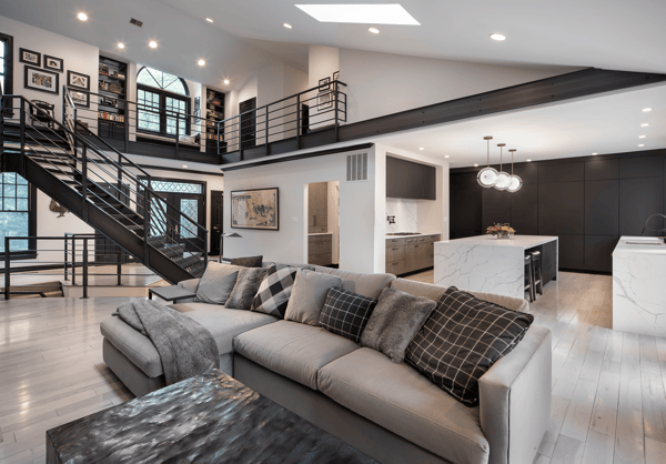 Loft style living room with open concept kitchen with black metal staircase