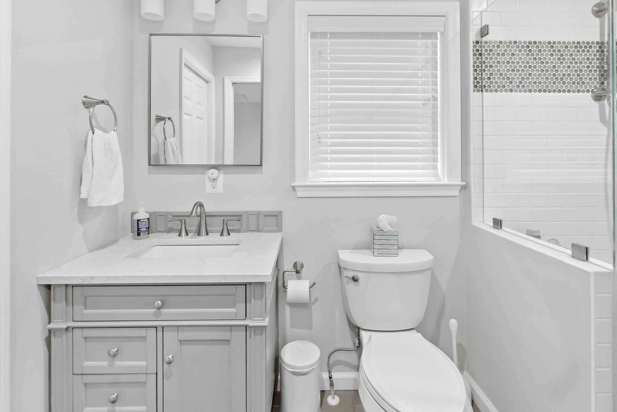 Clean white bathroom with one sink and vanity