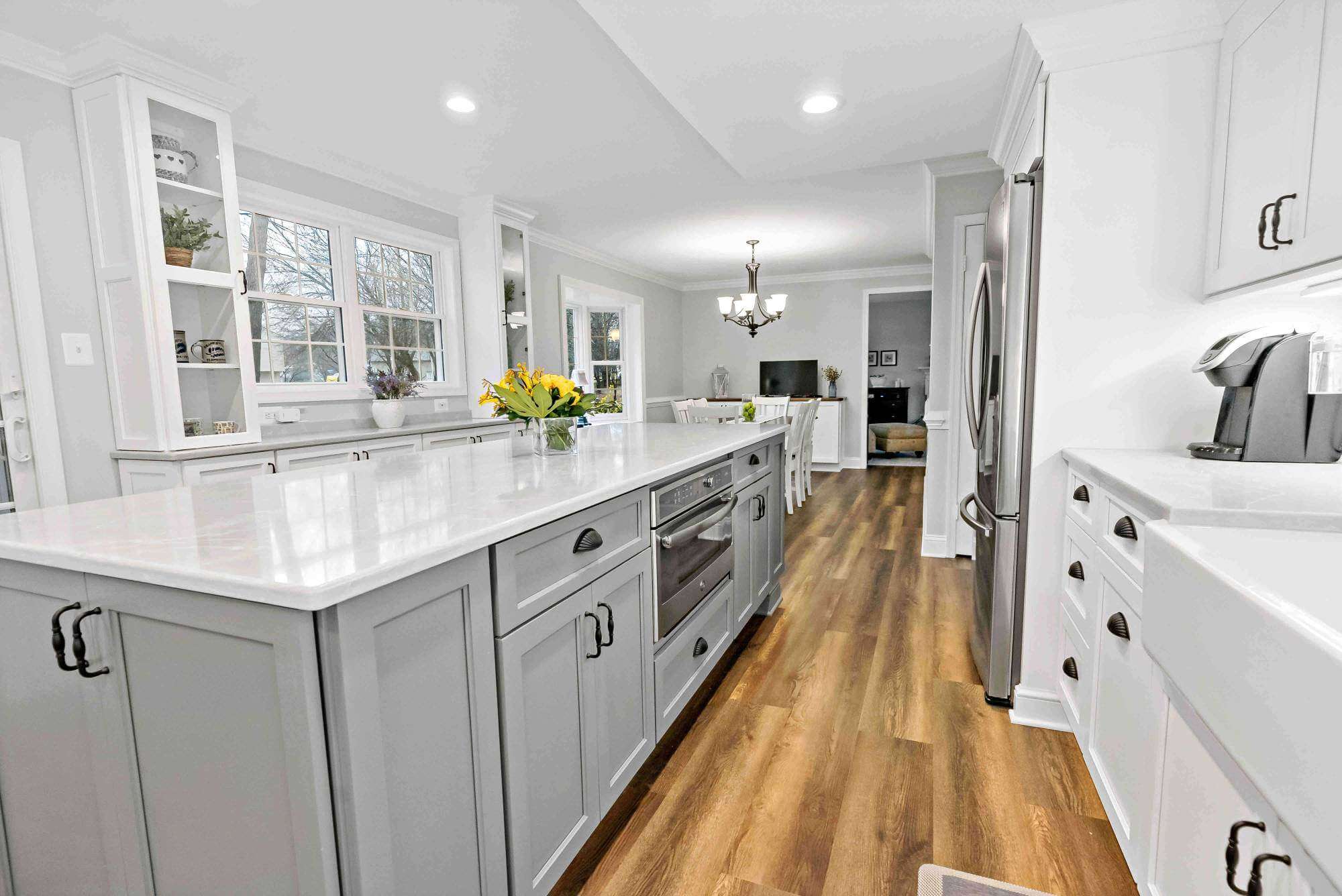 White and grey cabinetry with black handles in kitchen