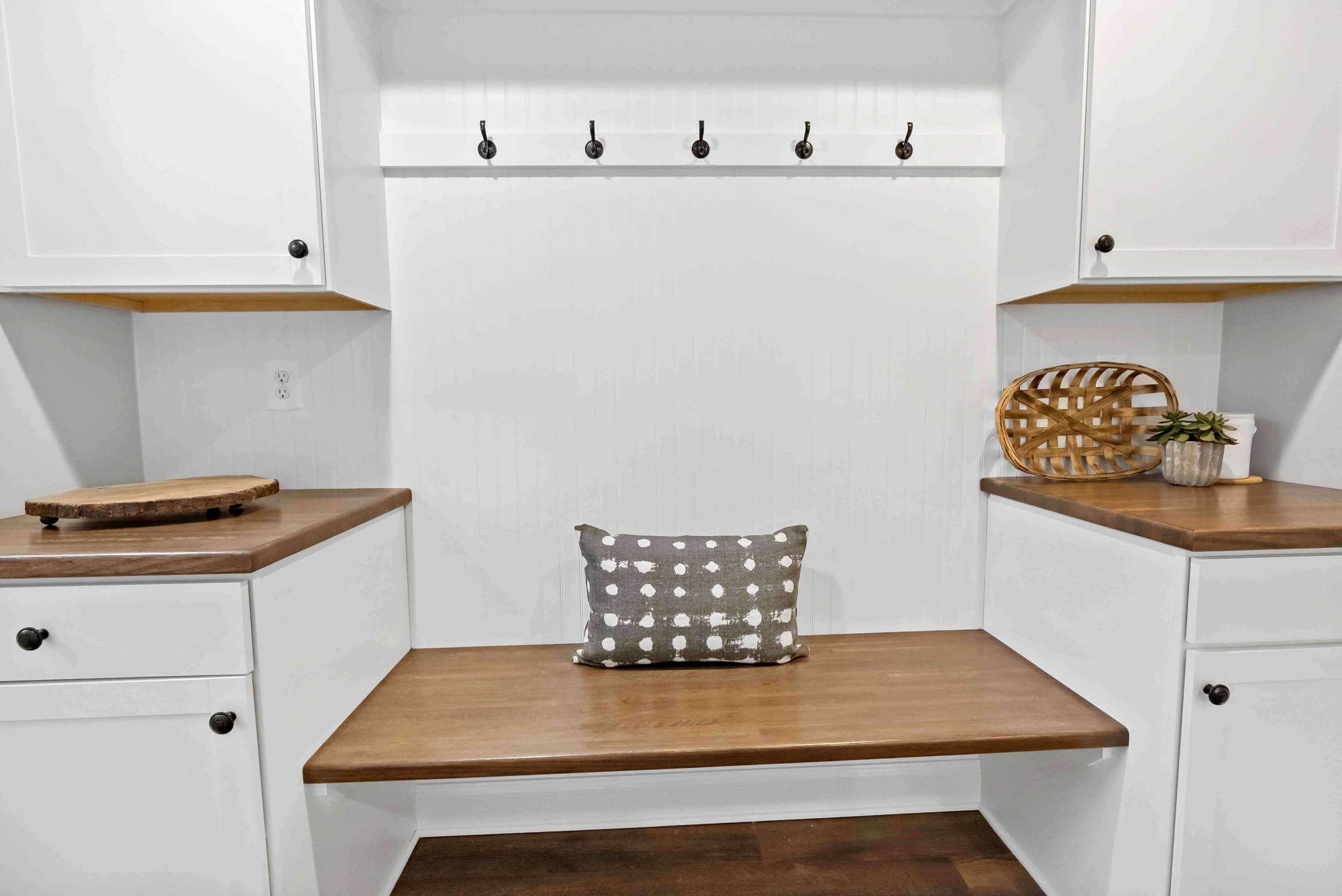 White mudroom with cabinets and bench