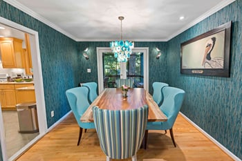 Textured blue wallpaper in dining room with blue chairs