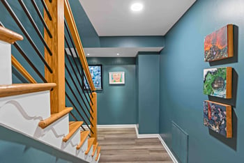 Blue walls surround brown railing staircase