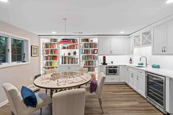 White cabinetry in basement kitchen with kitchen table