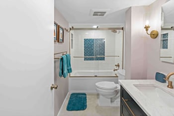 Full bathroom with bathub shower and light pink walls