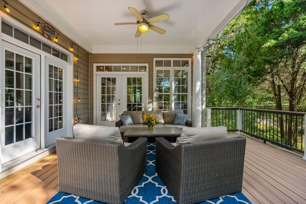 Outdoor patio covered with ceiling fan and two doors to enter home