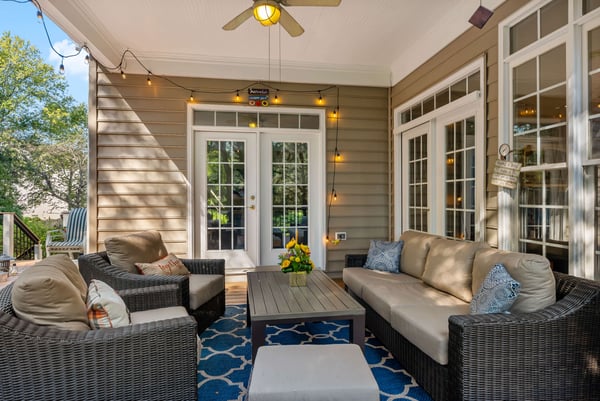 Cozy quaint covered porch with outdoor furniture and string lights