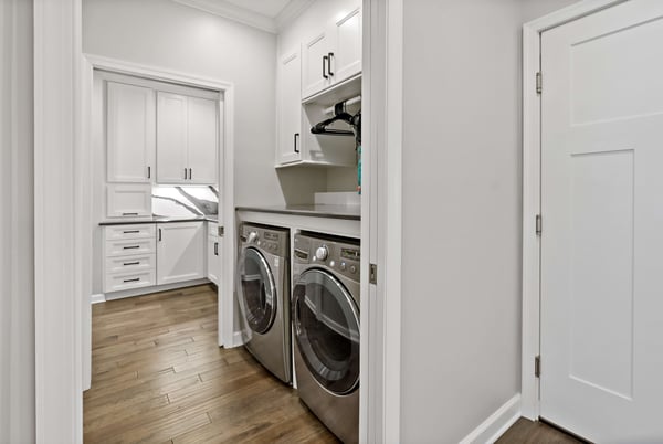 Laundry room with white cabinetry and pocket doors