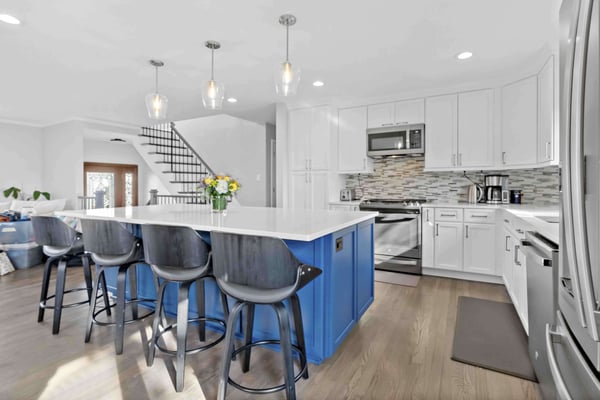 Sleek white kitchen and dark blue island