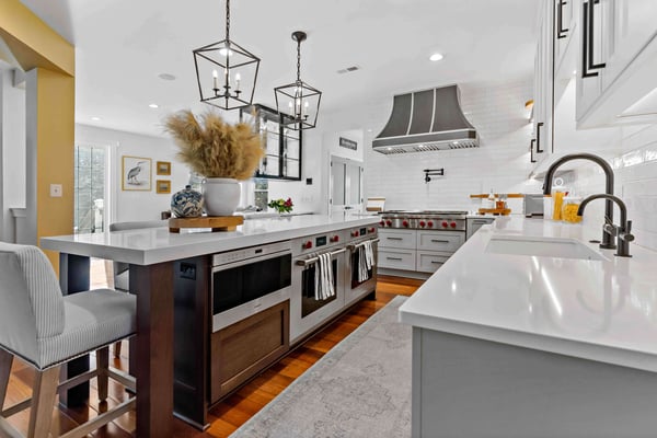 Modern and sleek kitchen with white professional grade gas stove, range, and dual ovens from SubZero Wolf Appliances