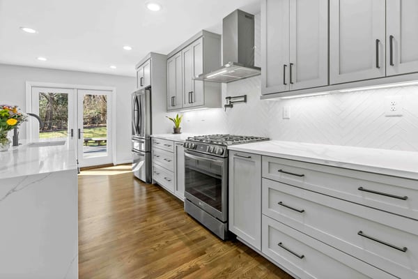 Light grey kitchen with white rectangle backsplash in open minimalist kitchen