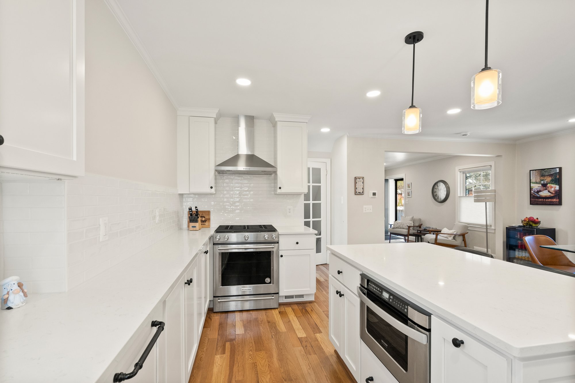 Modern kitchen remodel in Arlington with large island, stainless steel range, pendant lighting, and seamless transition to open living area for family connection.