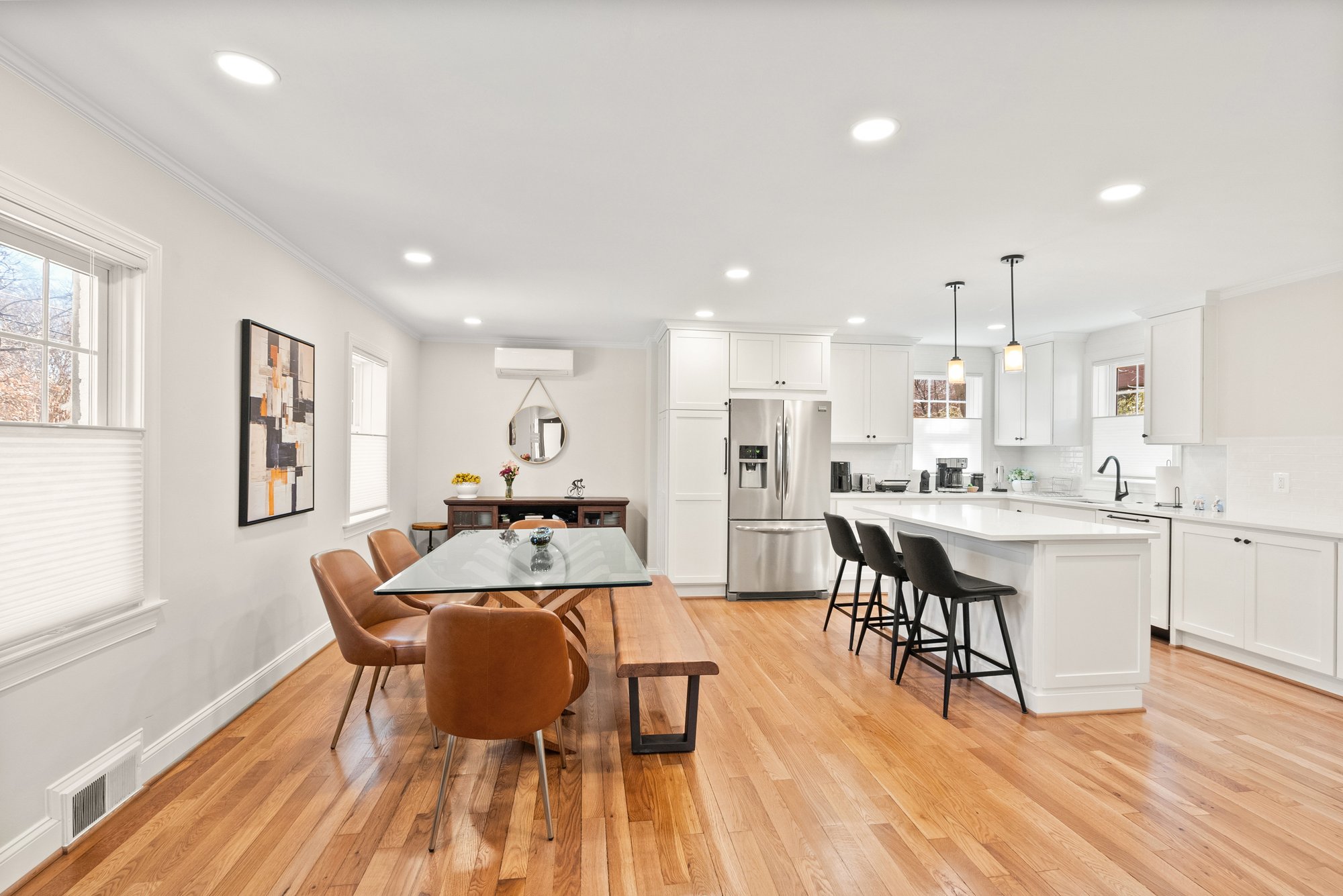 Open concept Arlington, VA kitchen and dining area remodel with white cabinetry, large island, and hardwood floors designed for family gatherings and entertaining.