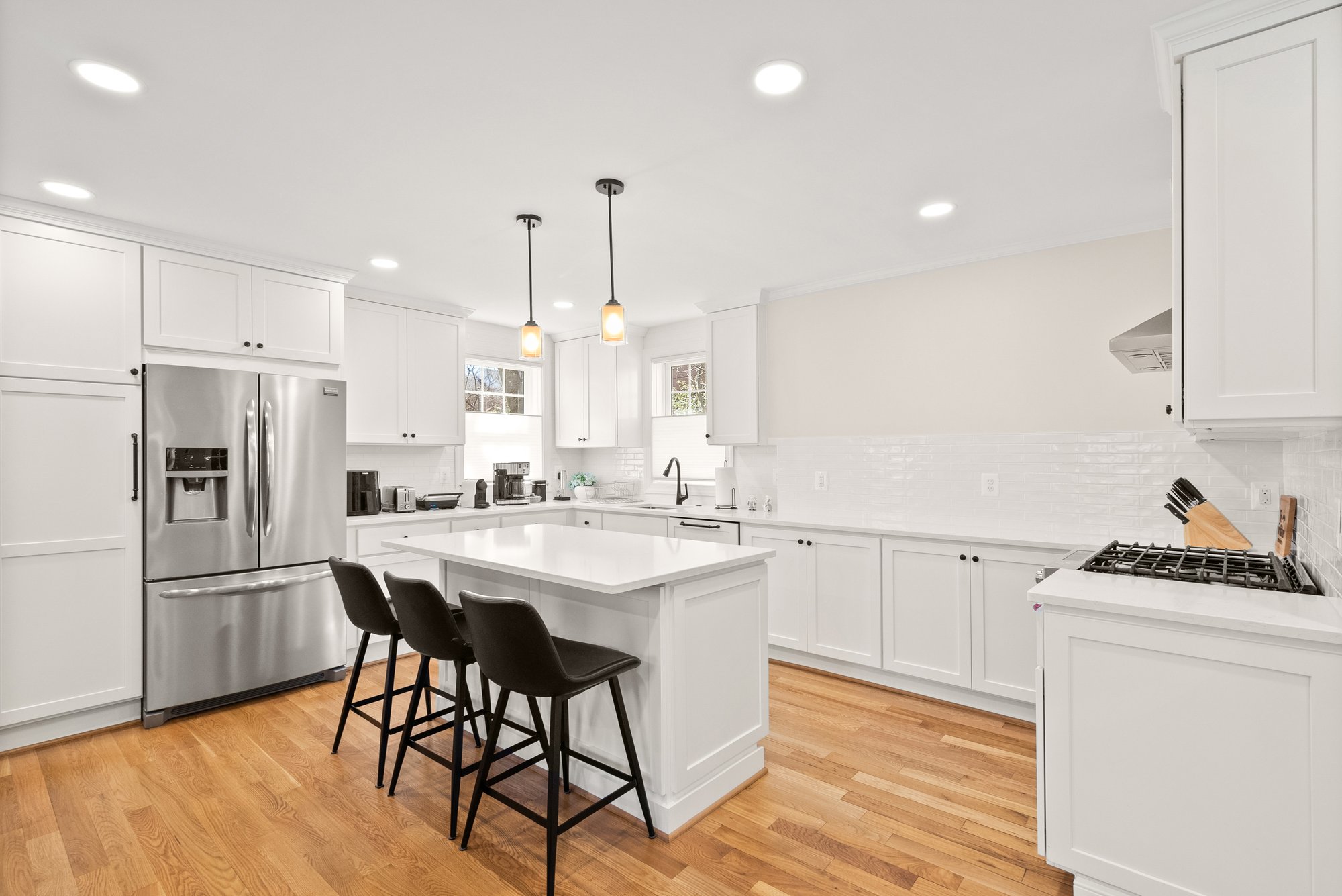 Bright kitchen with hardwood floors, pendant lights, and stainless steel appliances in Arlington VA