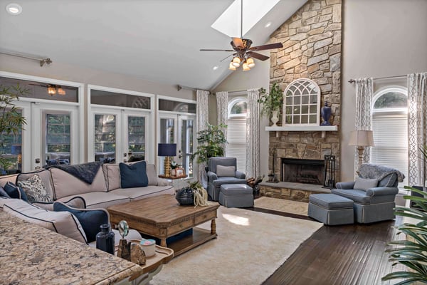 Stone fireplace and blue furniture accents and dark hard wood floors in living room