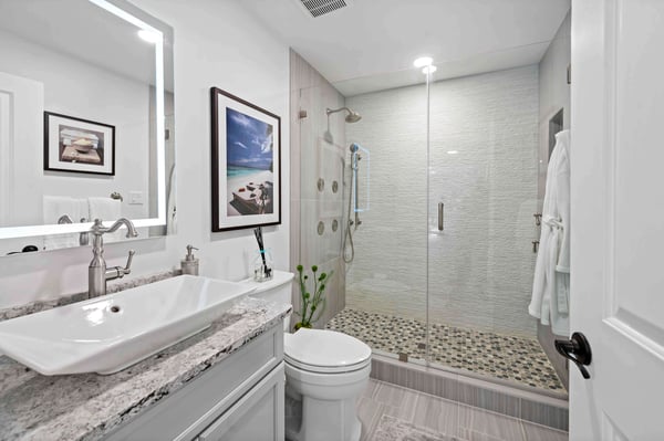 Shades of brown countertop and shower tile in full bathroom