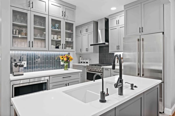 Small silver kitchen with glass cabinets and island