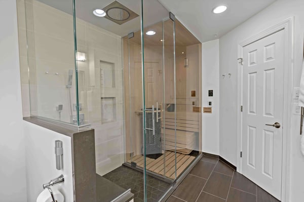 Walk-in curbless shower and sauna with glass walls