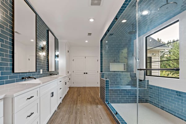 Master bathroom and walk-in shower designed with blue tile and bench