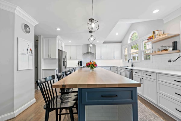 White kitchen with white countertops and blue island with brown countertop