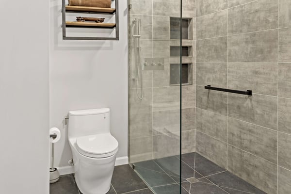 Dark bathroom tile with curbless shower and brown tile