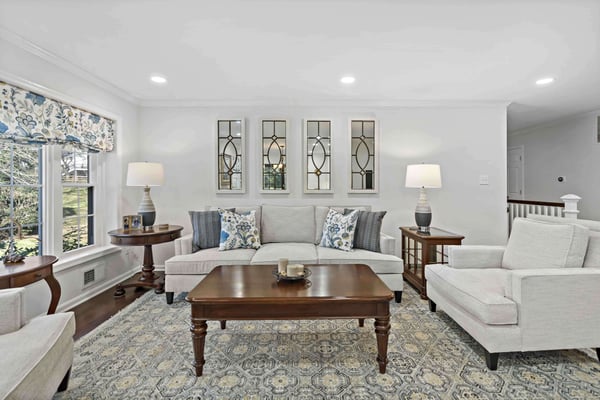 Soft white couches with dark wood furniture and flooring