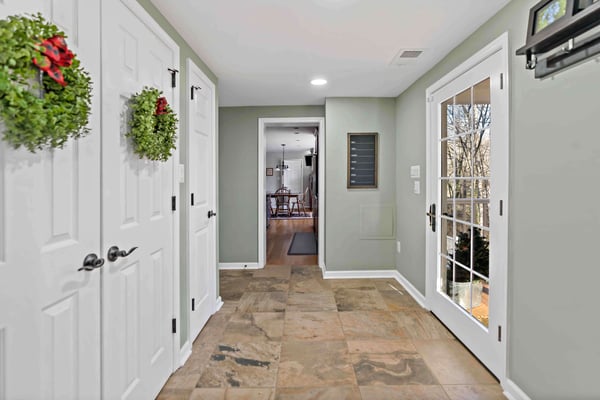 Wreathes hung in hallway of home with green walls and brown floor tiles