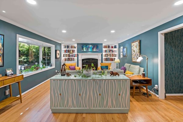 Blue walls in colorful basement with built in bookshelves and fireplace