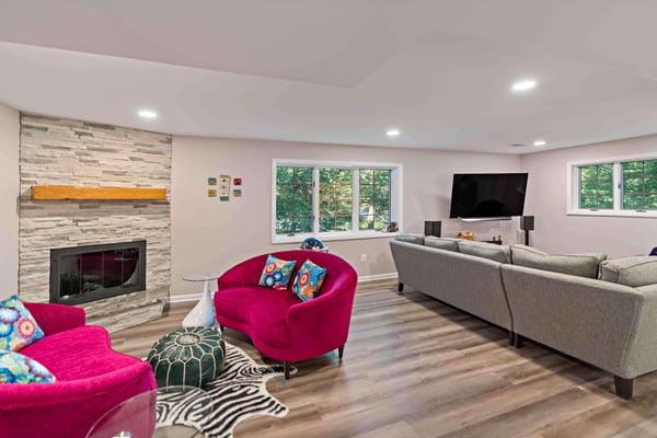 Neutral colored basement with pop of pink furniture