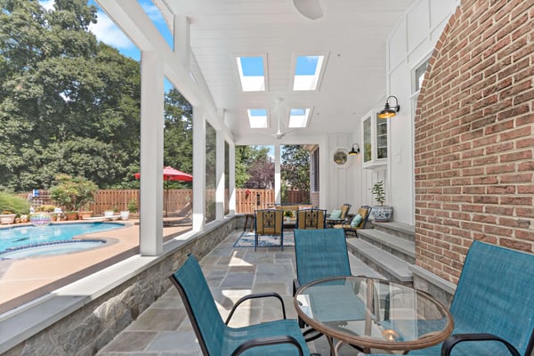 Covered patio with stone tile flooring and inground pool