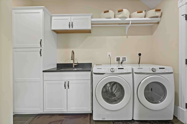 White laundry room with cabinet storage