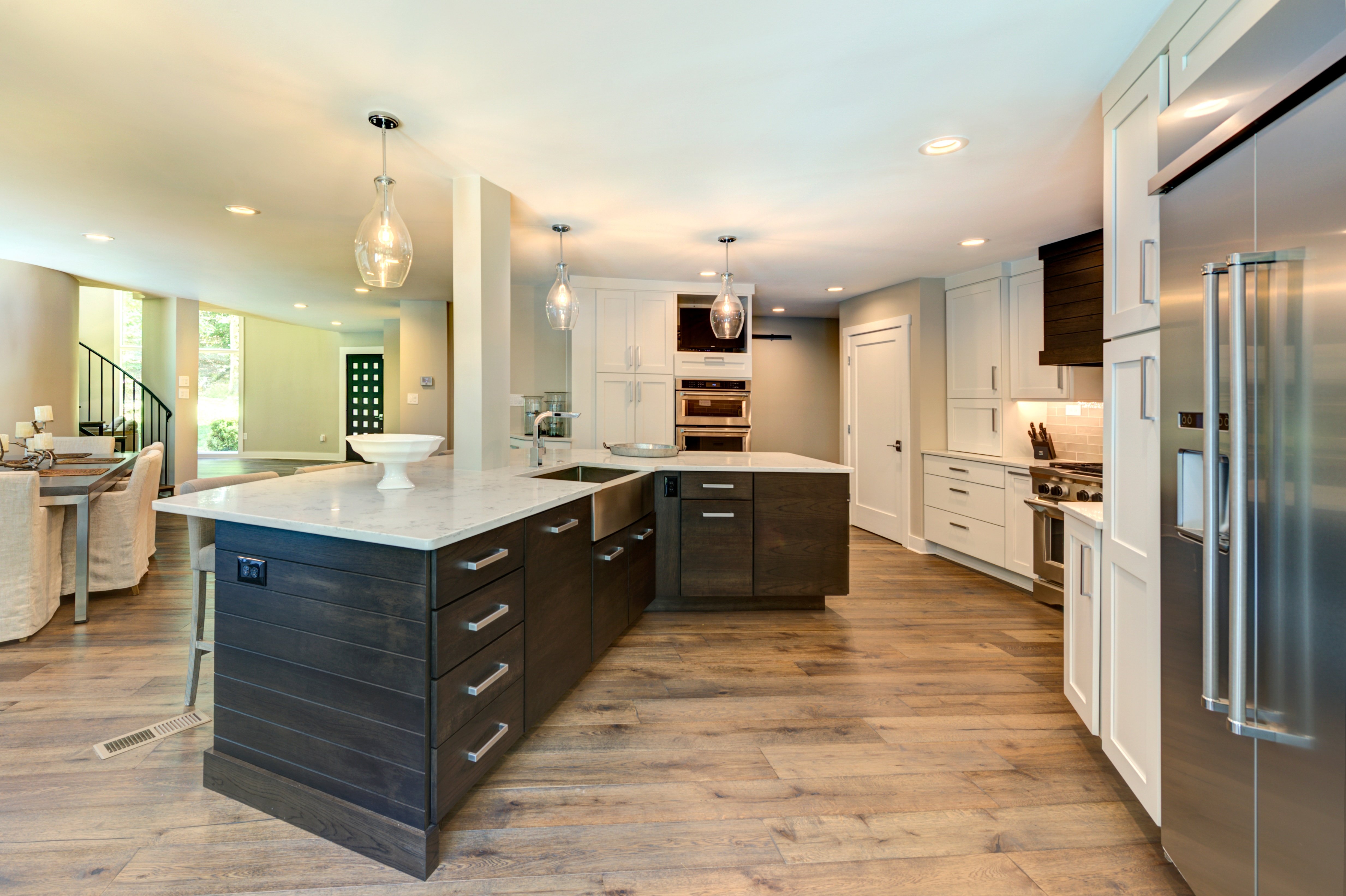 Hard wood floors and dark brown cabinets with white countertops in kitchen
