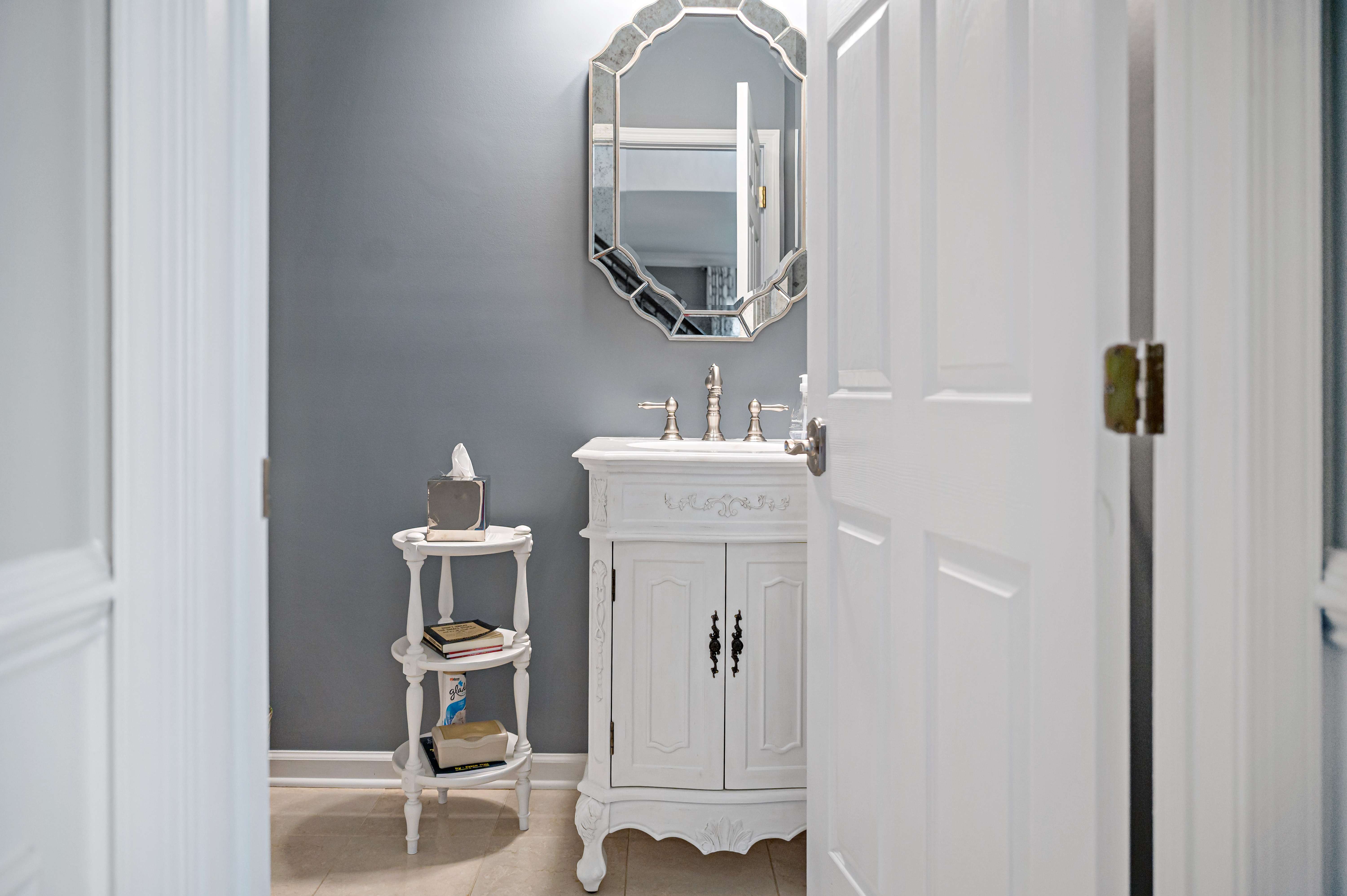 Half bathroom with antique vanity and oval mirror