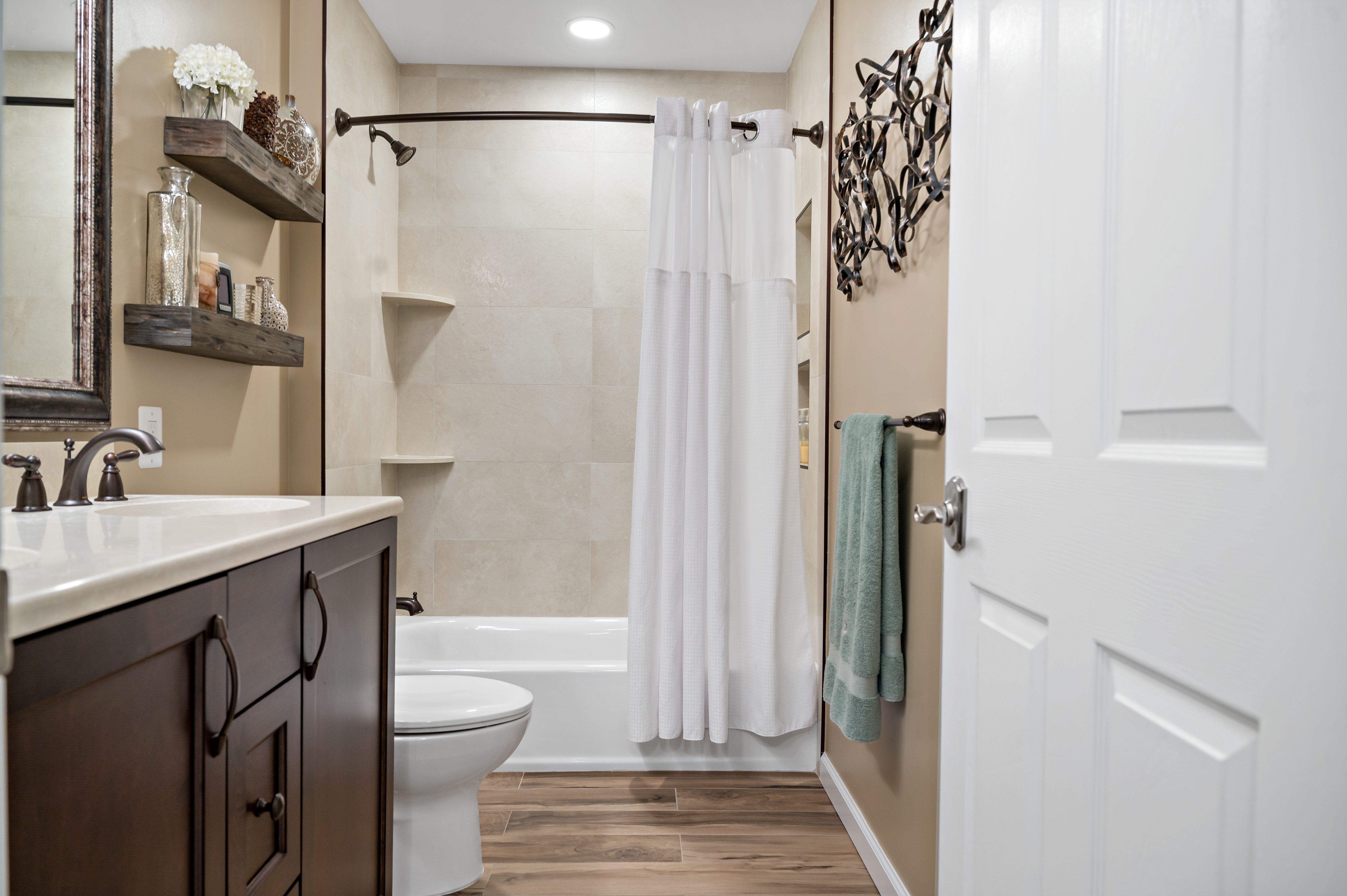 Bathtub shower combo in bathroom with hard wood floors