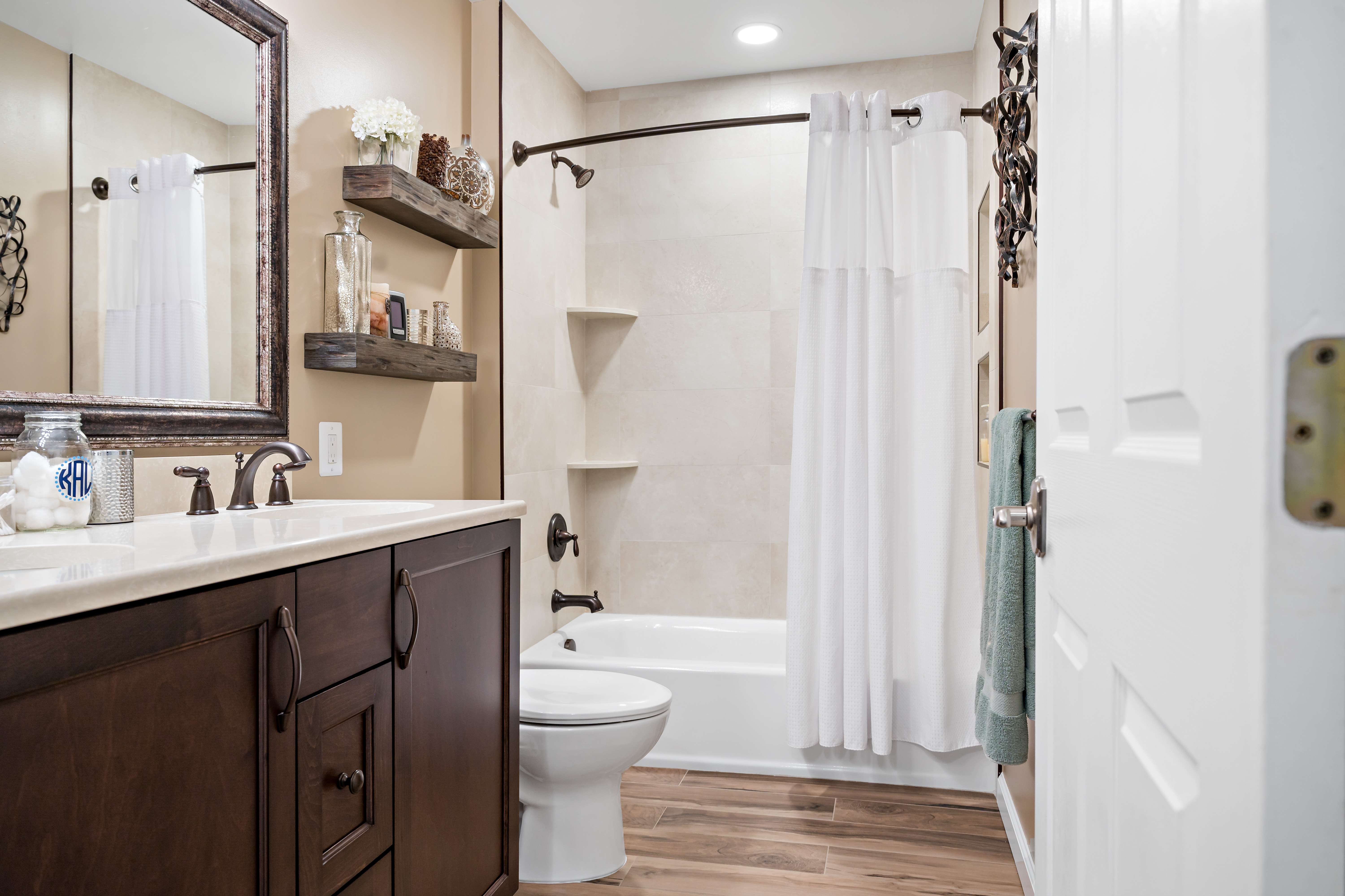Brown cabinets and white countertops in full bathroom