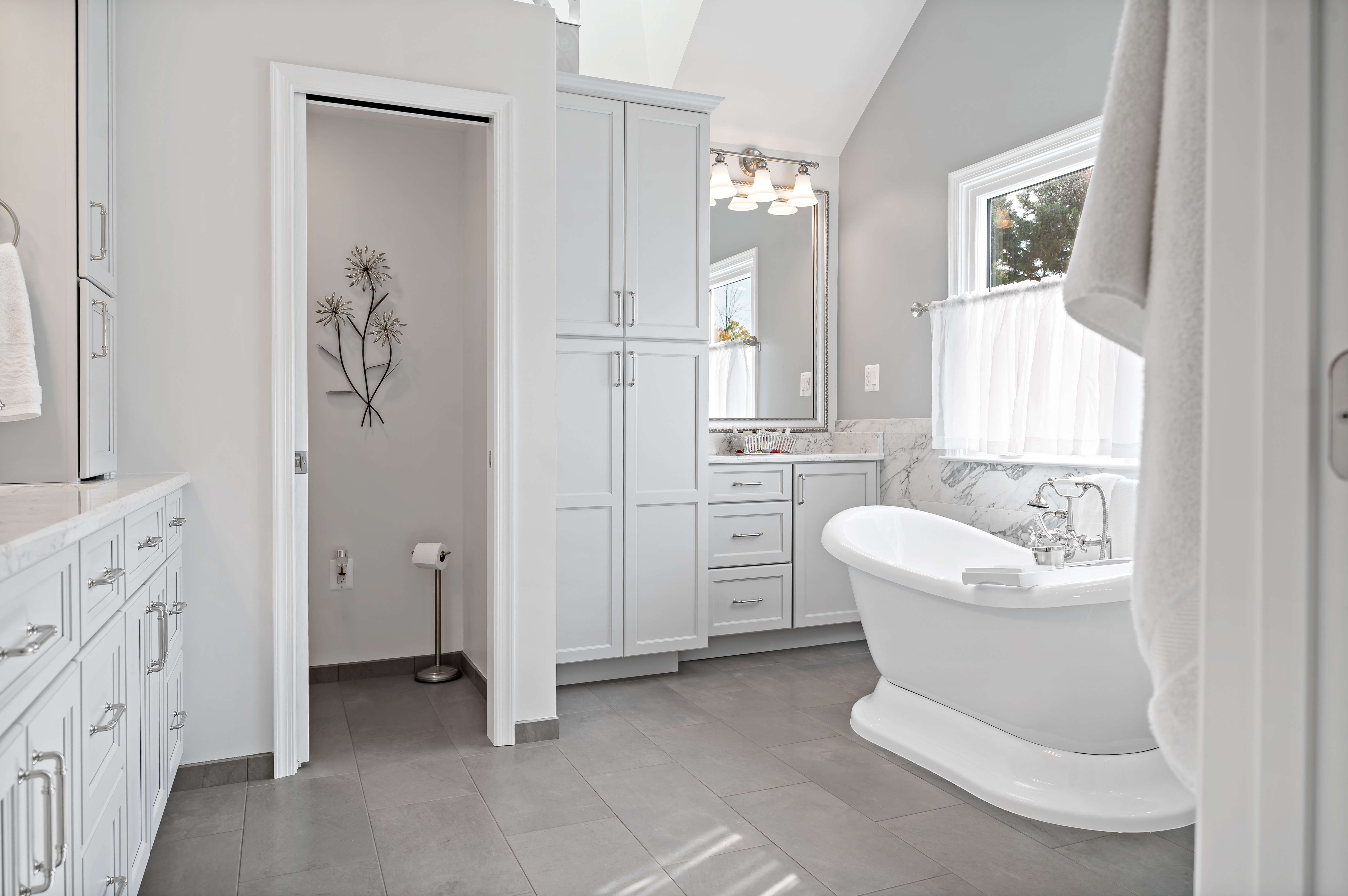 Tall white cabinets for storage in bathroom