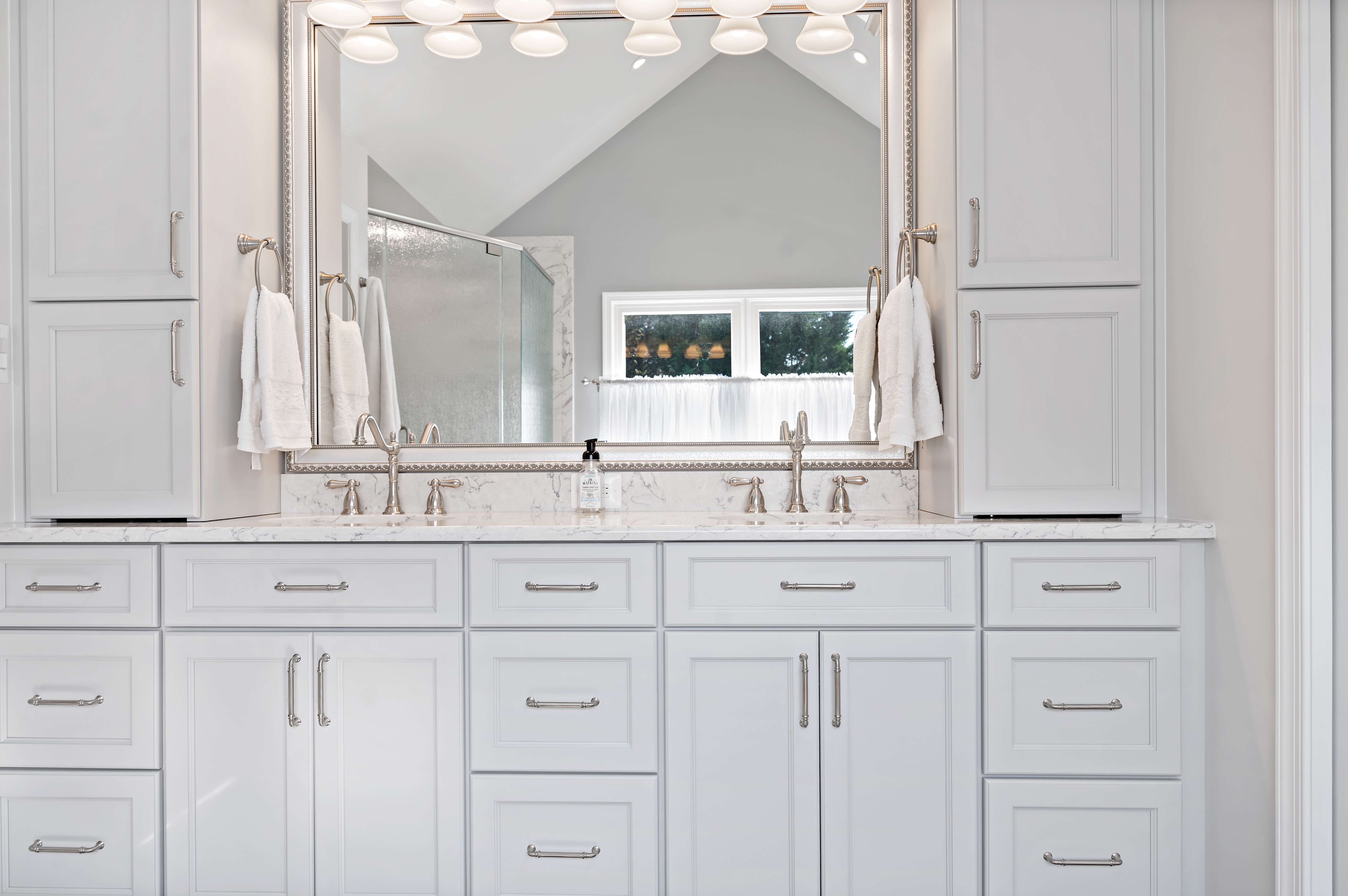 White cabinets and vanity with double sinks in bathroom