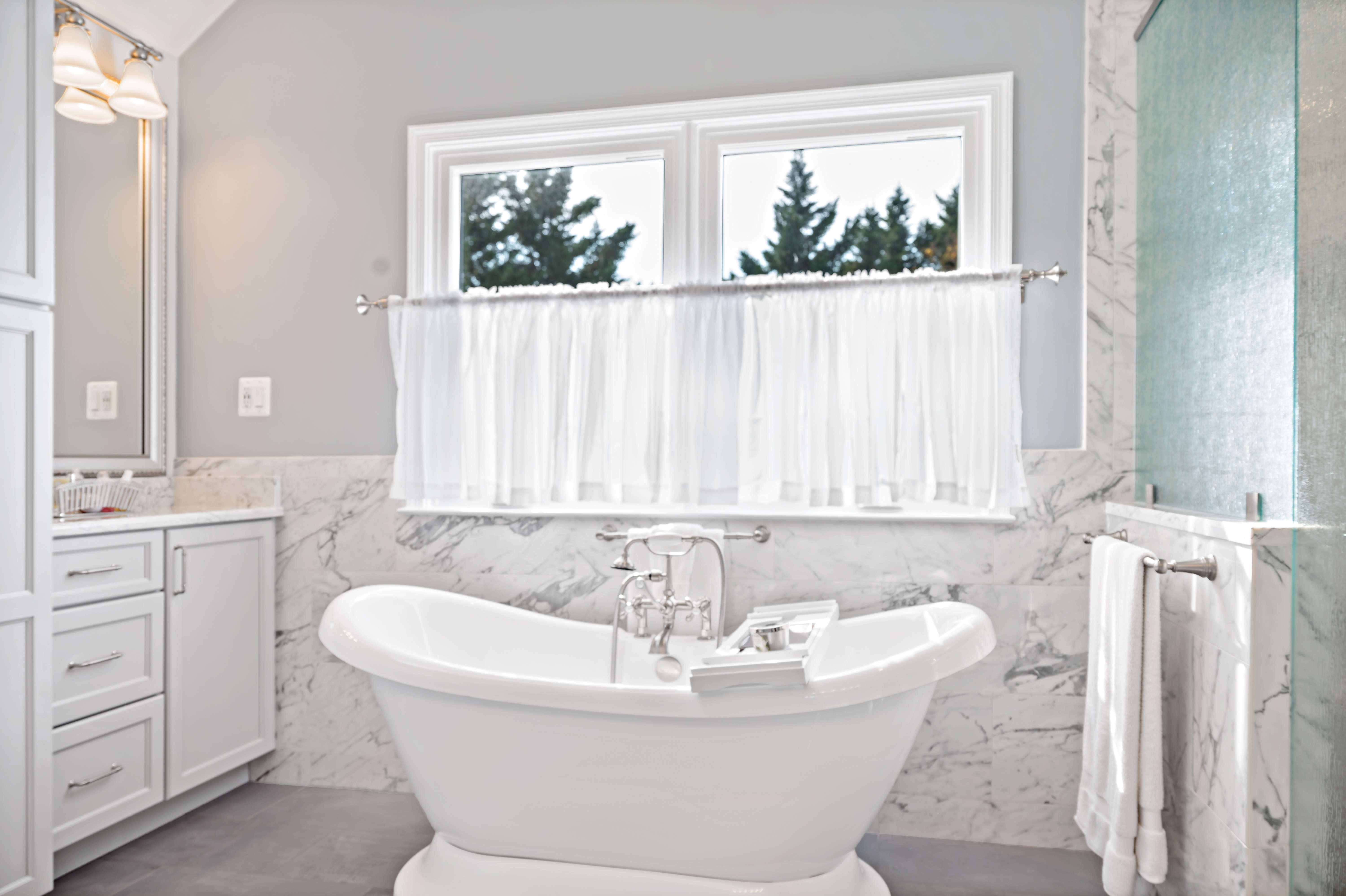Stand-alone white bathtub with window above