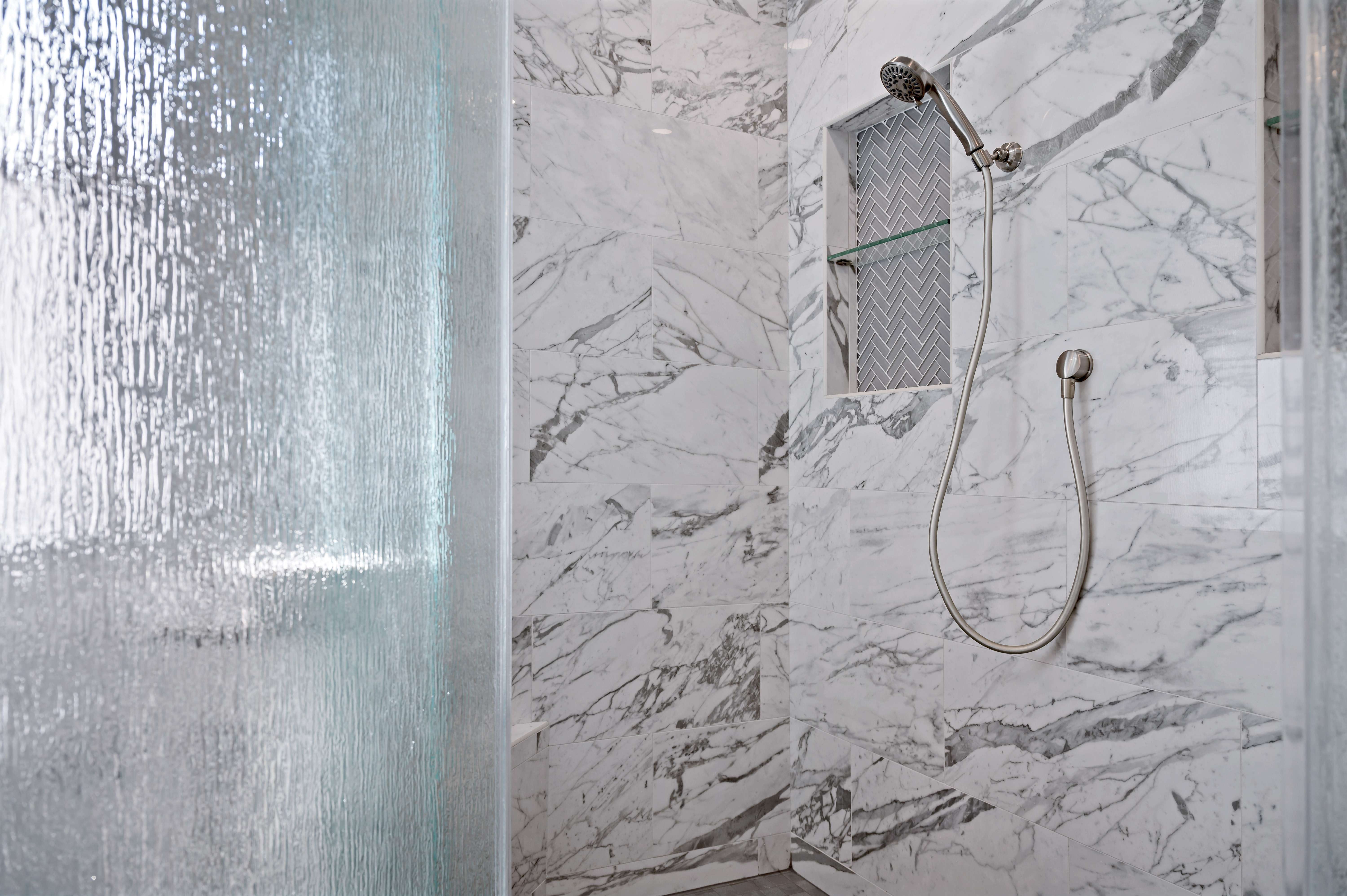 Marble tile in walk-in shower with removable shower head