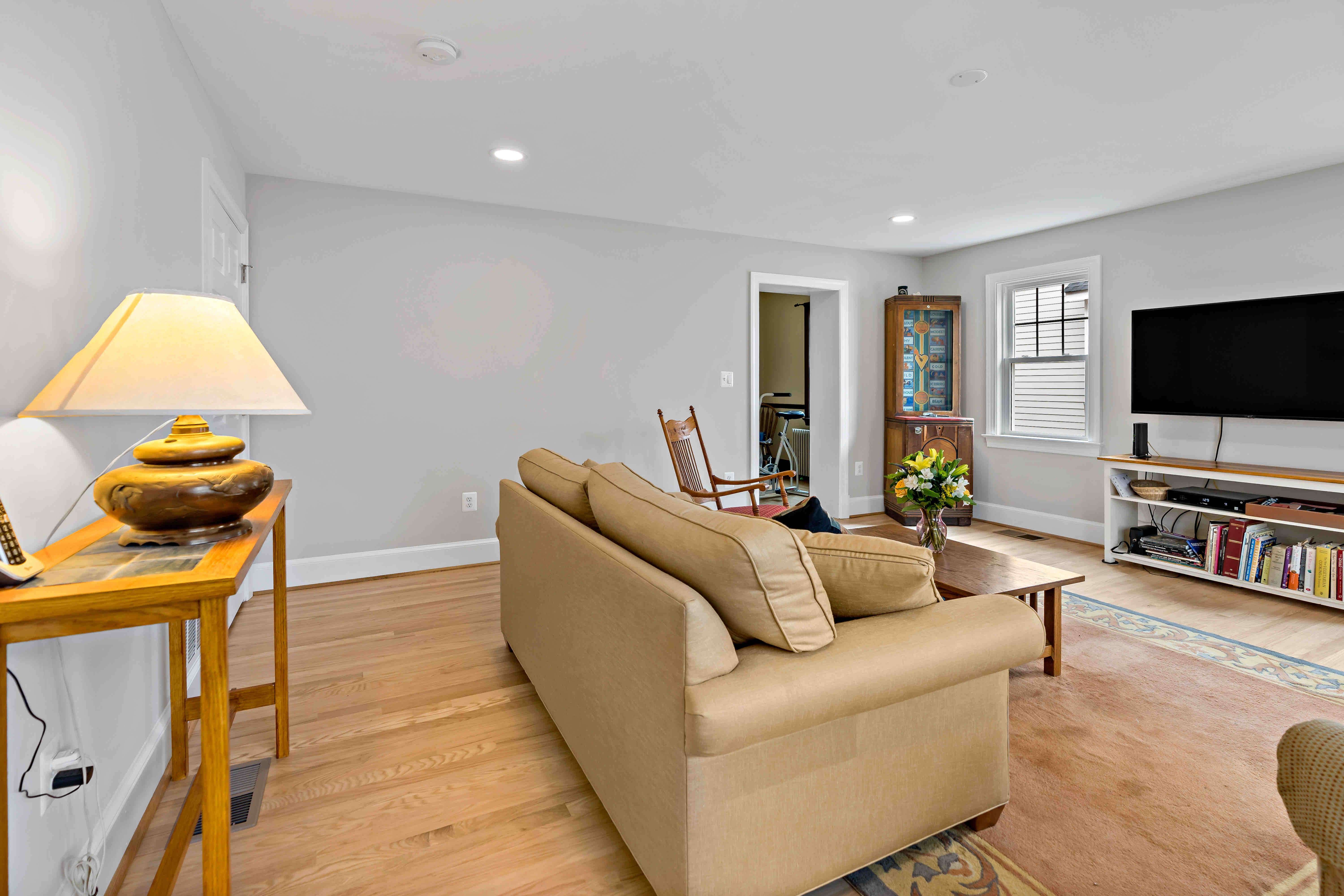 Entertainment room with hardwood floors and white walls