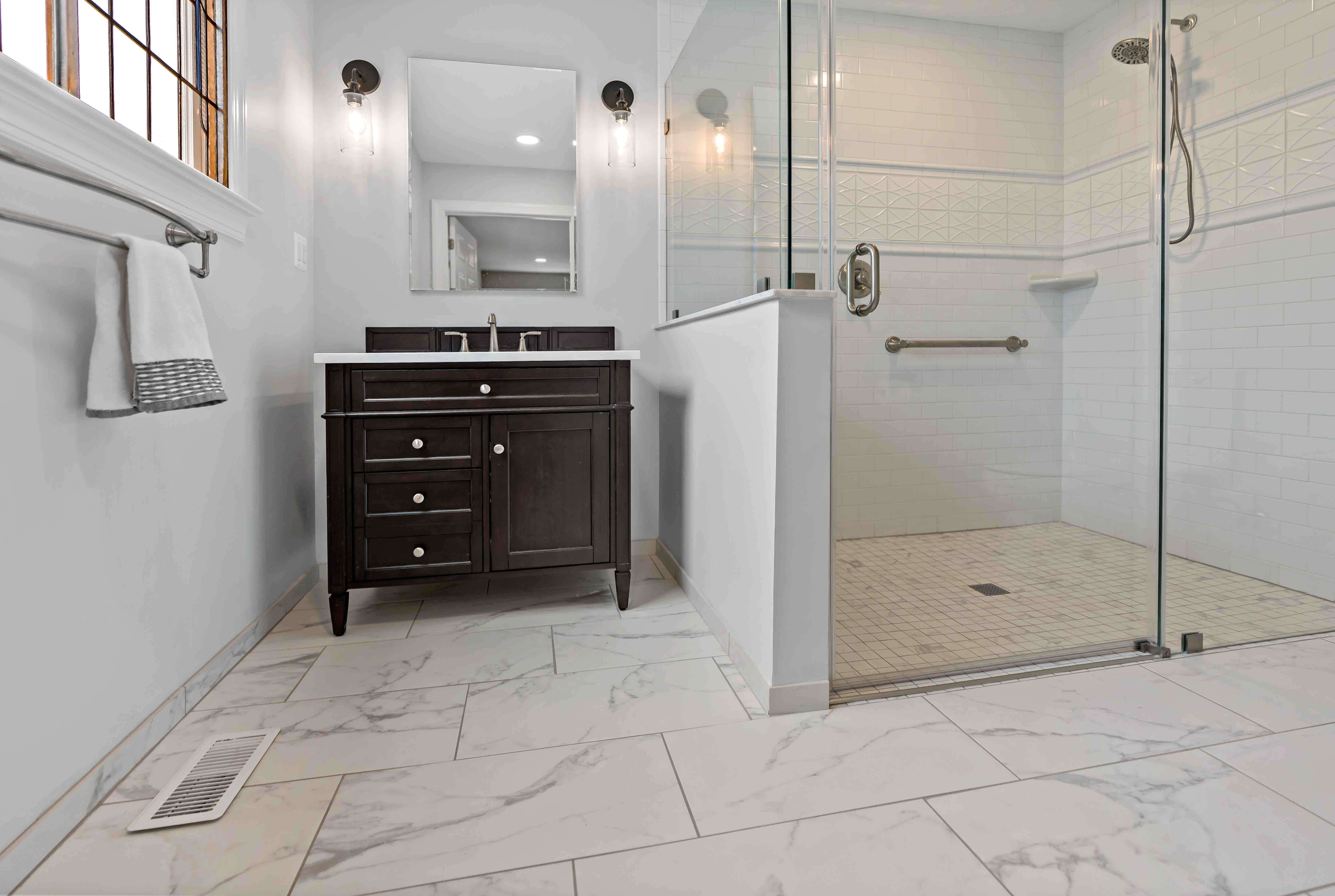 Curbless walk-in shower with glass walls and glass door
