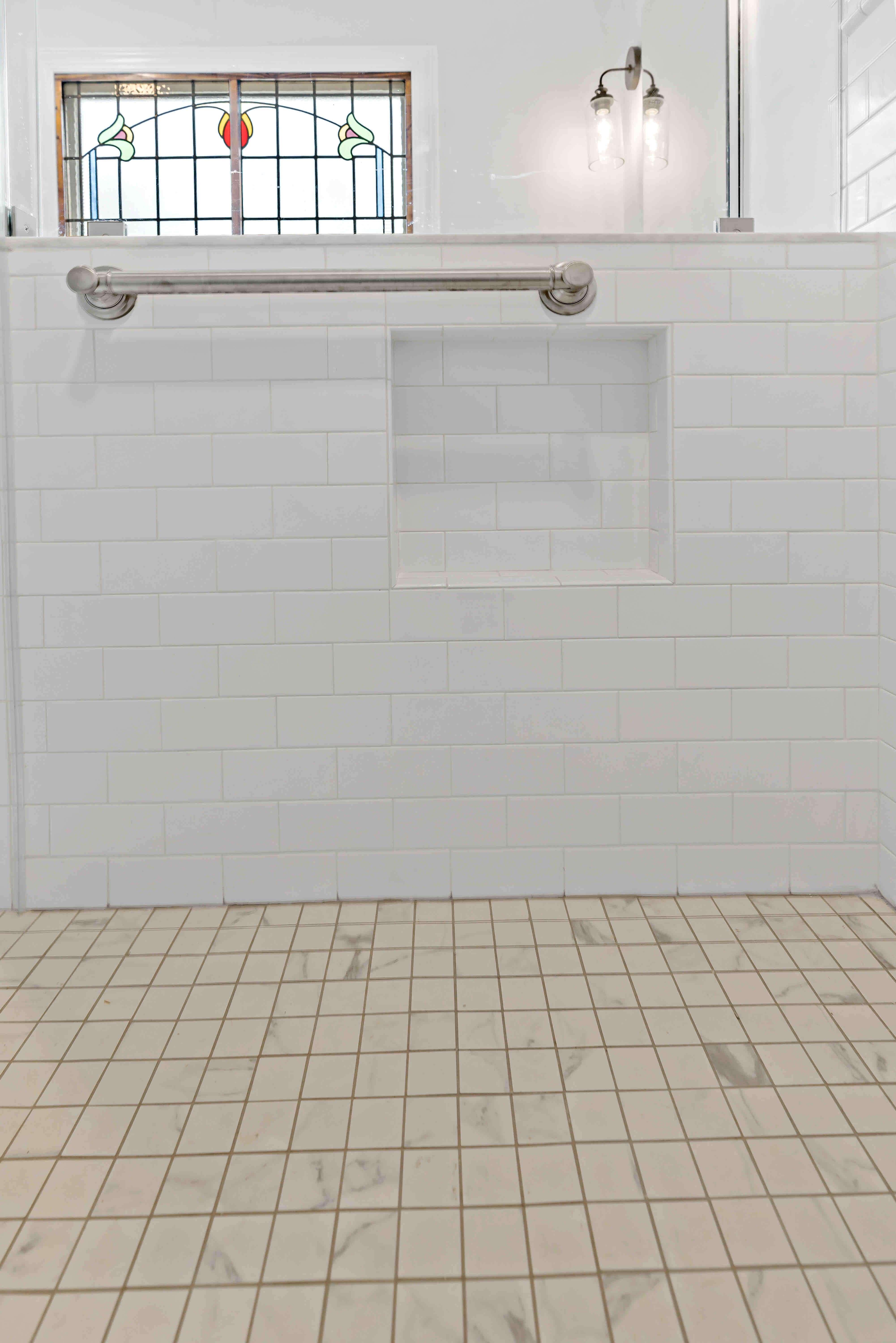 White shower tile walls and beige tile floor