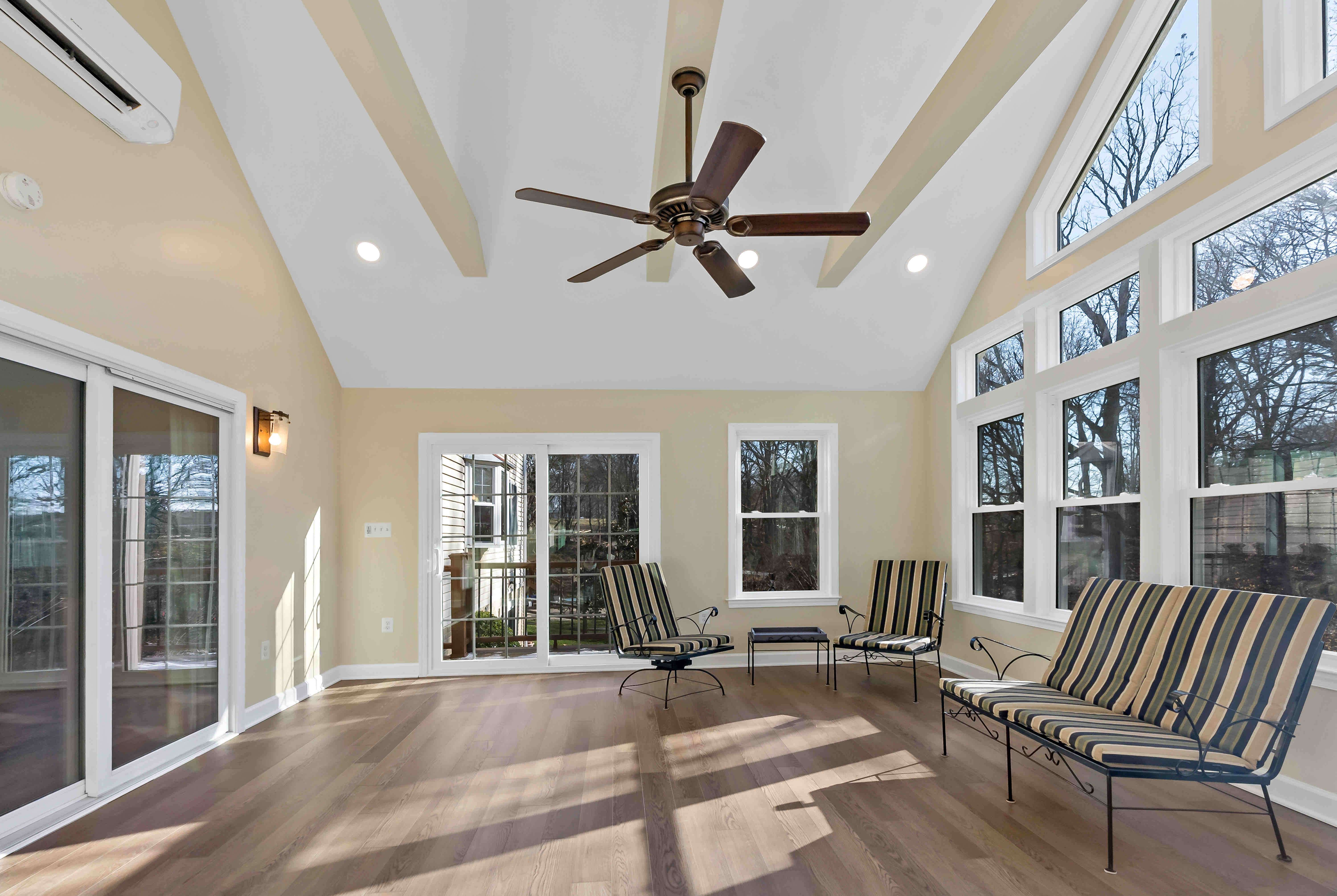 Wood beams on ceiling in sunroom with hardwood floors