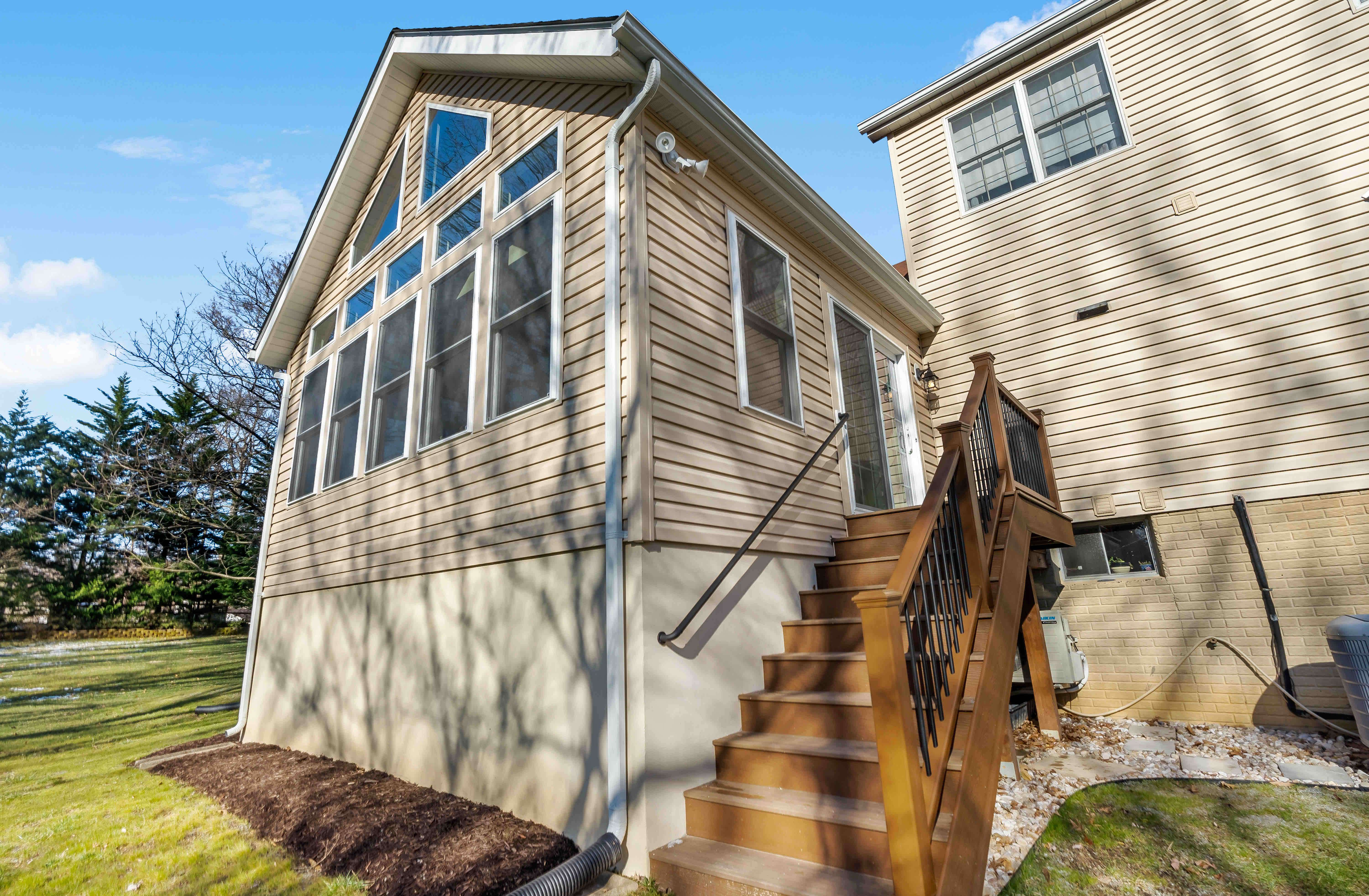 Sunroom on back of house with stairs leading to backyard