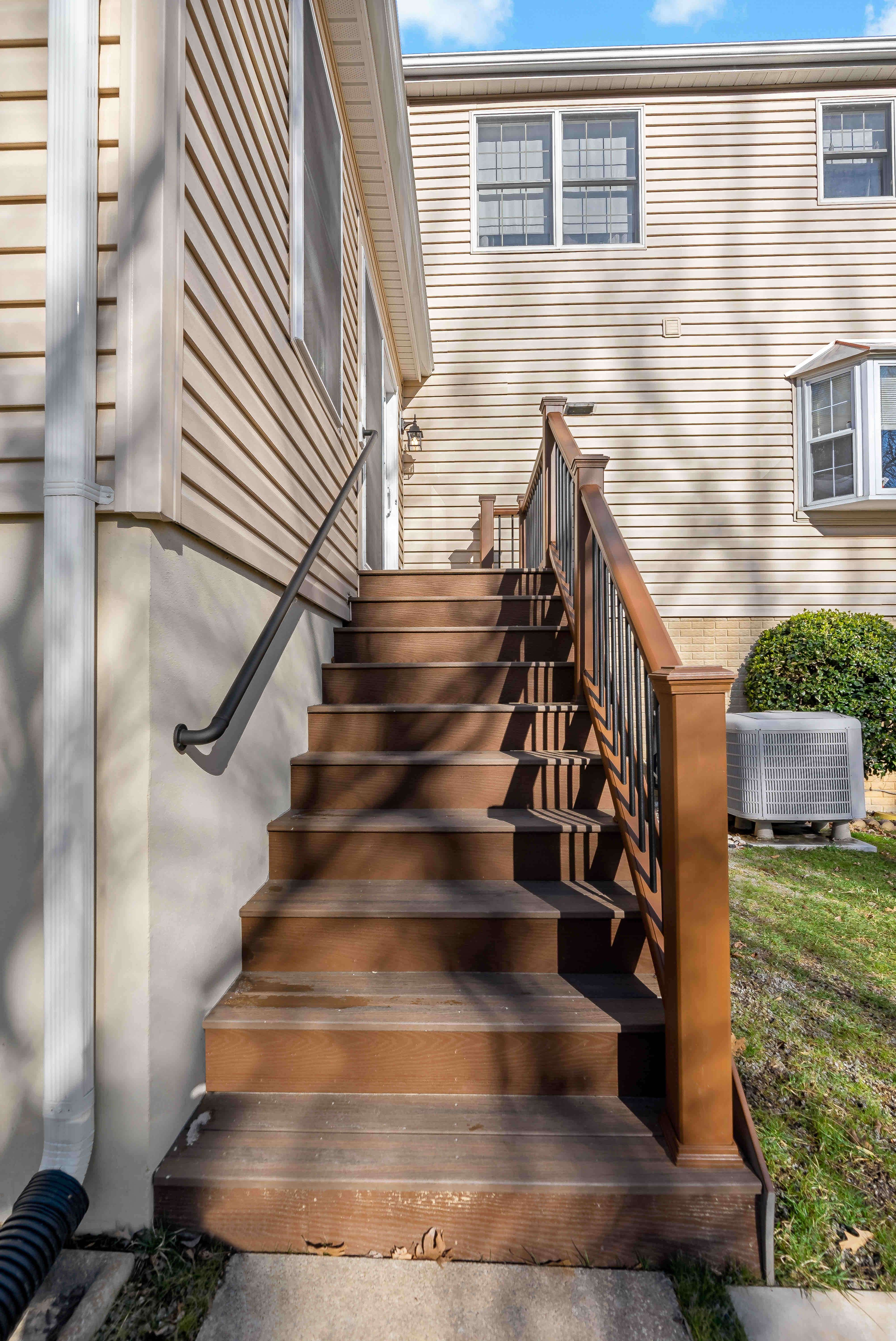 Wooden stairs with railing to enter and exit sunroom to the outside