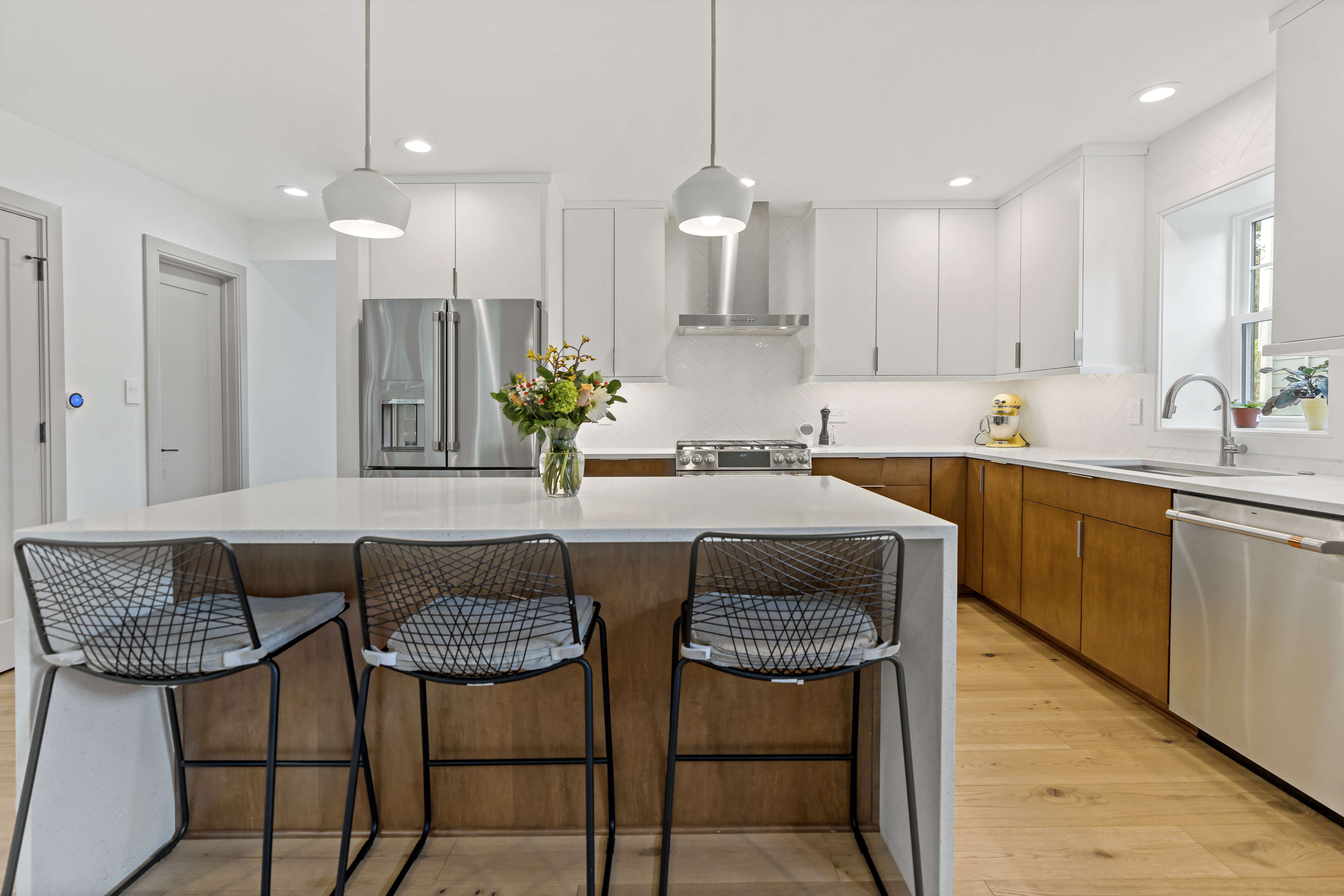 Large white counter kitchen island with two pendant lights above